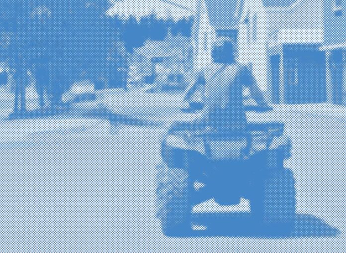 four-wheel ATV and rider on a town street.