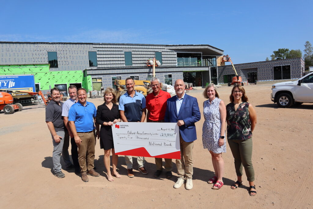OCC Committee Members Troy Miller, Paul Jones, Jordan Burkhardt, Matthew Bragg, David Hoffman, Leta MacDiarmid, and Chrystal MacNutt pose with National Bank representatives Anne Guimond-Nadeu and Shawn O'Brien on-site at the Oxford Community Centre.